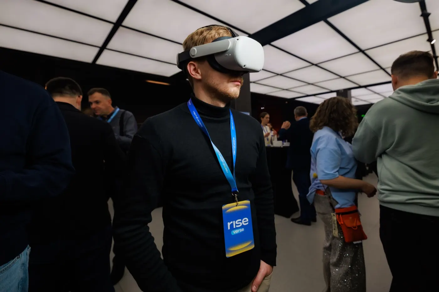 Дмитро Круглов у VR-окулярах тестує проєкт на стенді в експо-зоні RISEverse